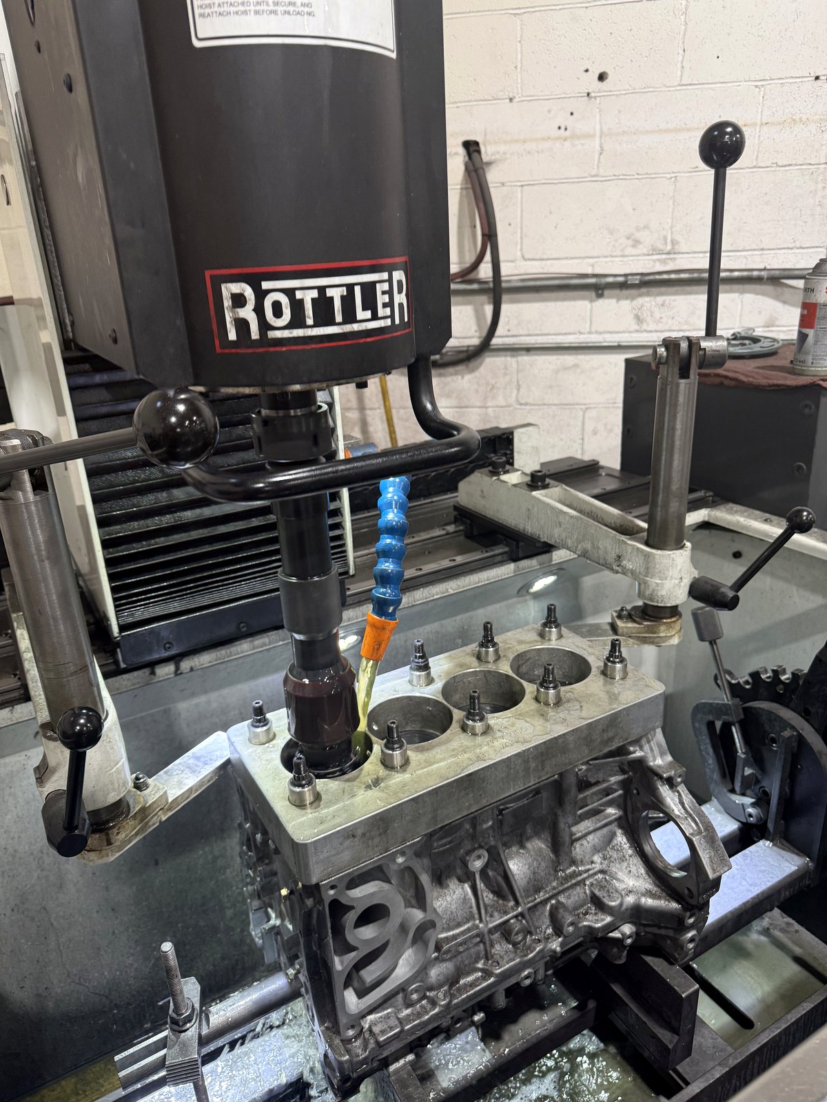 Rodage des cylindres d'un bloc moteur sur un équipement Rottler dans l'atelier.
